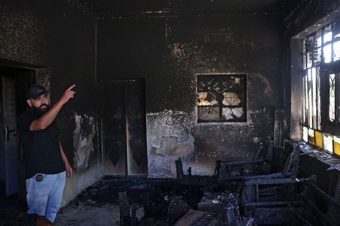 A Palestinian gestures inside his home, which was set on fire by Israeli settlers the day before, in Turmus Aya near Ramallah.